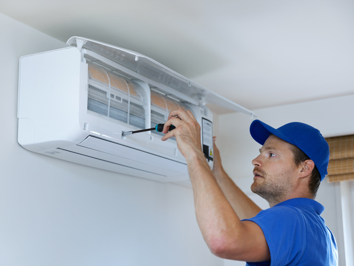 Air conditioning installer fitting a wall-mounted unit in a London home